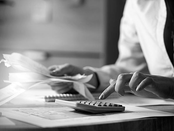 black and white image of man using a calculator